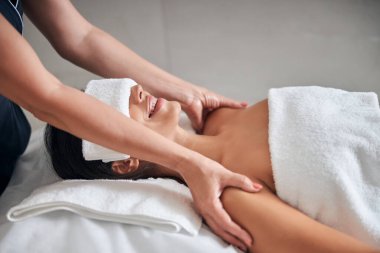 Masör elleri kaplıcada genç bayanların omuzlarına masaj yapıyor.