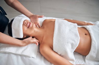 Masör elleri spa salonunda kadın boynu masajı yapıyor.