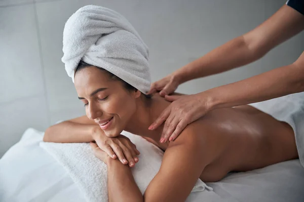 Masseuse handen masseren jonge vrouw terug in spa salon — Stockfoto