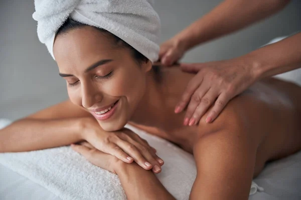 Massaggiatrice professionista massaggiando femminile indietro nel salone spa — Foto Stock