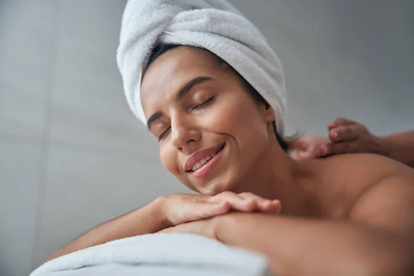 Mooie jonge vrouw genieten van massage in spa salon — Stockfoto