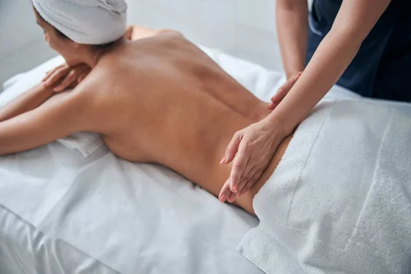 Jonge vrouw ontvangst terug massage in spa salon — Stockfoto