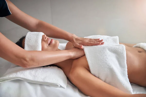 Mãos de massagista massajando peito feminino no salão de spa — Fotografia de Stock