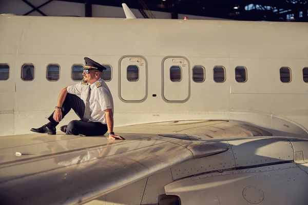 Pewny siebie pilot spędzający czas w hangarze na lotnisku — Zdjęcie stockowe
