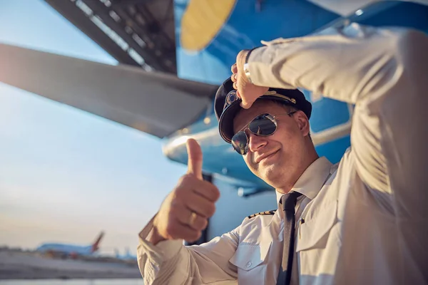 Впевнений повітряний капітан, який показує, як стоїть на відкритому повітрі — стокове фото
