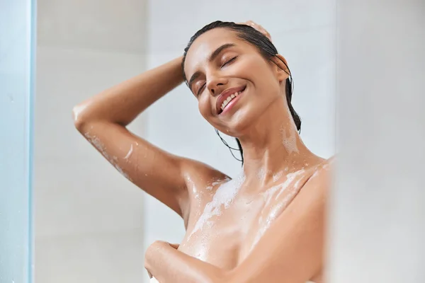 Attraente giovane donna che lava i capelli sotto la doccia — Foto Stock