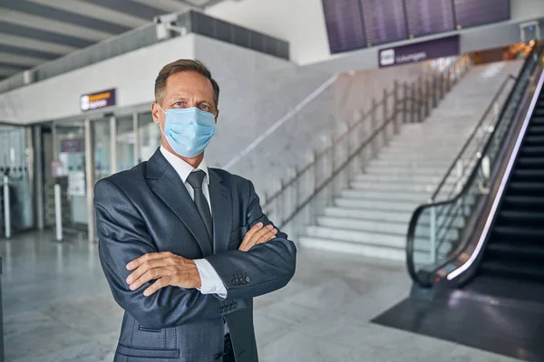 Seyahatte maske takan olgun bir iş adamı