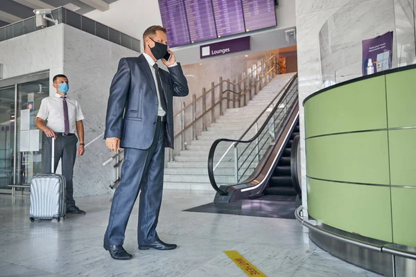 Empresário falando no celular no aeroporto — Fotografia de Stock