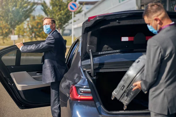 Элегантный бизнесмен с шофером прибывает в аэропорт — стоковое фото
