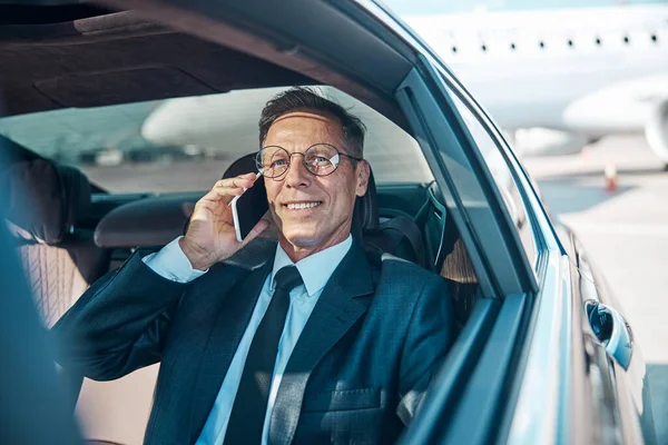 Счастливый бизнесмен делает звонок после посадки на самолёт — стоковое фото