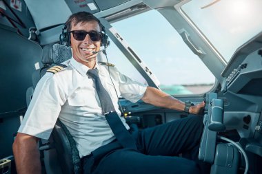 Gülümseyen yakışıklı pilot uçaktaki işinden zevk alıyor.