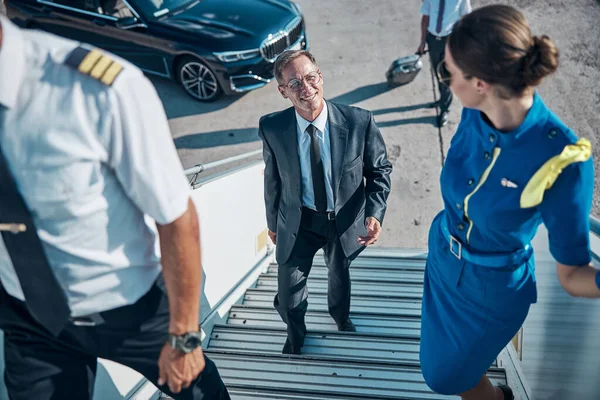 Welcoming jet staff meeting elegant male passenger — Stock Photo, Image