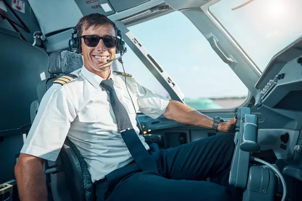 Lachende knappe piloot geniet van zijn werk in vliegtuigen — Stockfoto