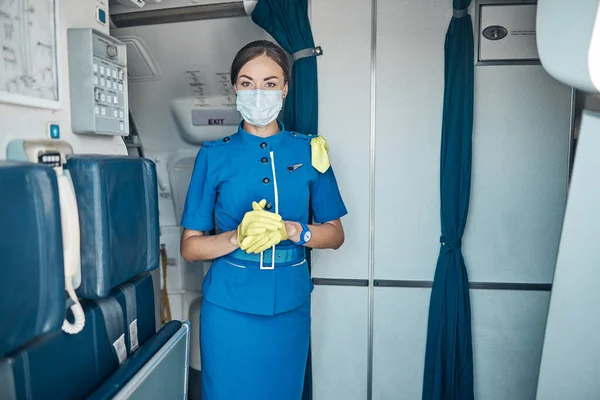 Prachtige stewardess aan boord tijdens pandemie — Stockfoto