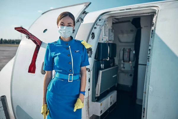 Csinos stewardess üdvözli az utasokat a kényelmes repülőn — Stock Fotó