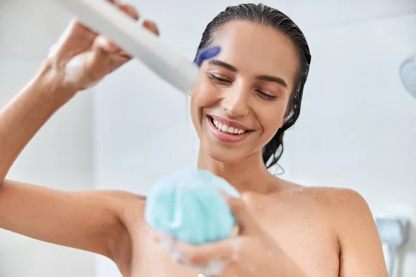 Charmante junge Frau gießt Duschgel auf Badeschlauch — Stockfoto