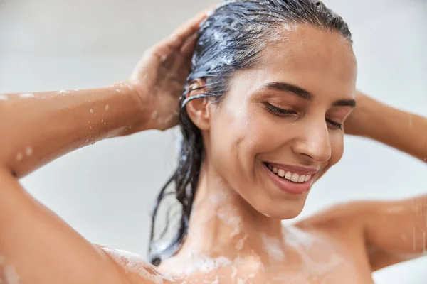 Radostná mladá žena mytí vlasů ve sprše — Stock fotografie