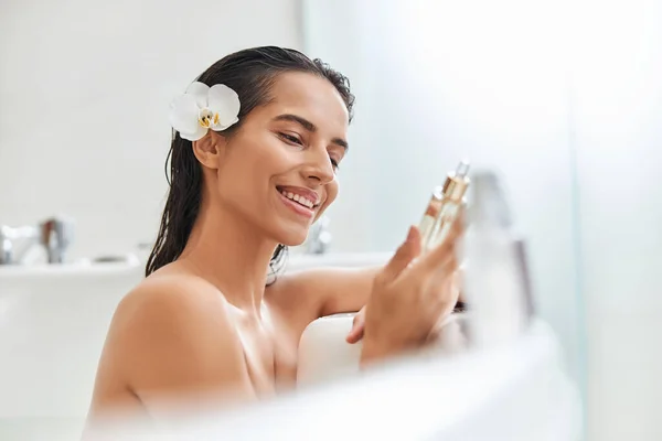 Radostná mladá žena drží vitamin sérum při koupeli — Stock fotografie