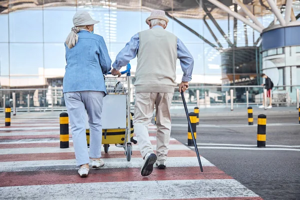 空港ターミナルに手荷物を持っているシニアカップル — ストック写真