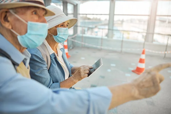 Twee oudere toeristen in het gezicht maskers staren in de verte — Stockfoto