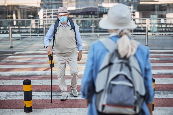 Ηλικιωμένοι τουρίστες διασχίζουν το δρόμο σε αντίθετες κατευθύνσεις — Φωτογραφία Αρχείου