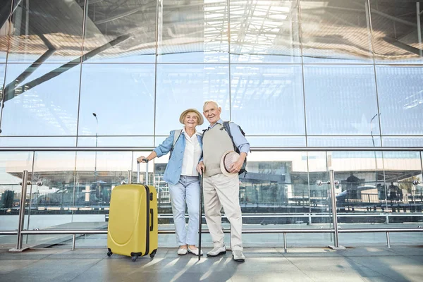 Cuplu încântat în vârstă în picioare lângă clădirea aeroportului — Fotografie, imagine de stoc