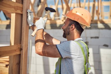 Cheerful young builder working at housing development clipart