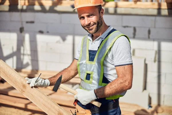 Retrato de trabalhador encantado segurando martelo em sua mão — Fotografia de Stock