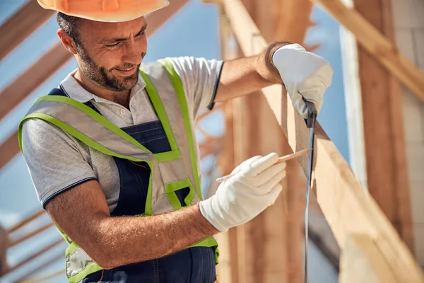 Positivo constructor encantado haciendo marca en la viga — Foto de Stock