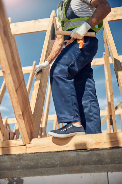 Фотография сильного человека, стоящего на балке