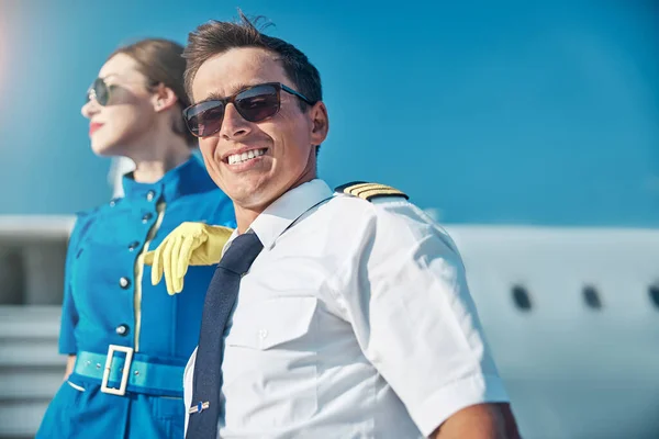 Happy young pilot resting after flight with colleague outdoors — Stock Photo, Image