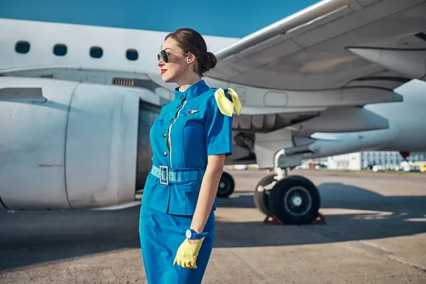 Sonriente azafata atractiva preparándose para volar — Foto de Stock