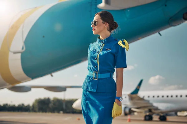 Cheerful pretty stewardess on runway in airport — Stock Photo, Image