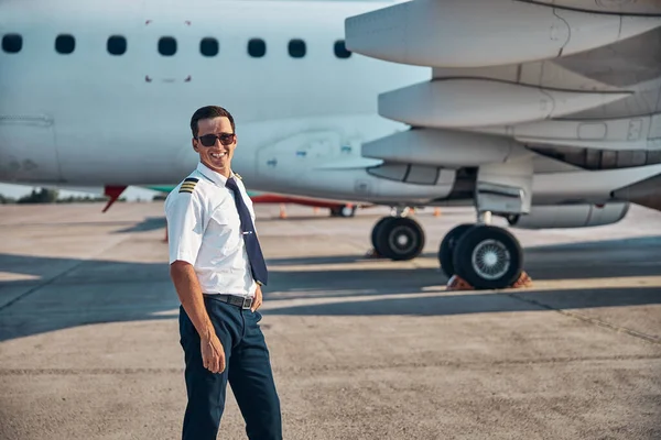Neşeli yakışıklı pilot uçuştan sonra dışarıda dinleniyor.