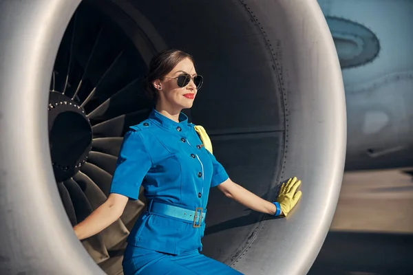 Feliz joven azafata sentada en turbina de chorro — Foto de Stock