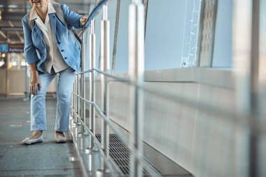 Yaşlı beyaz kadın iltihaplı dizine dokunuyor.