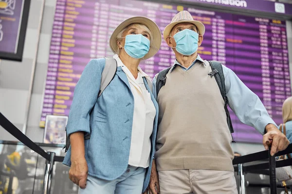 空港に立つ年配の女性と夫 — ストック写真