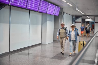 Mutlu evli çift havaalanı terminalinde yürüyor.