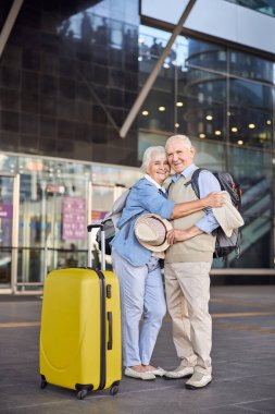 Dışarıda kocasını kucaklayan mutlu bir kadın turist.