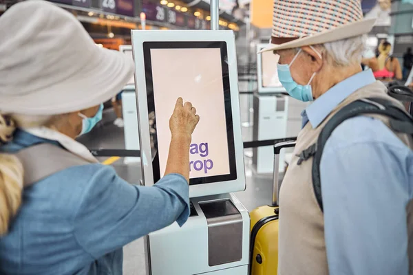 Dois passageiros seniores a fazer o check-in das suas bagagens — Fotografia de Stock