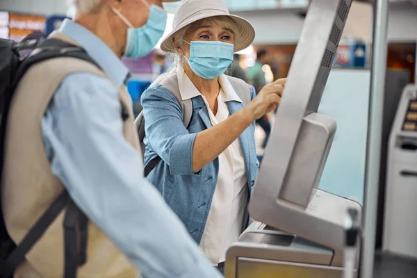 Idős turista pár bejelentkezik a beszállás előtt — Stock Fotó