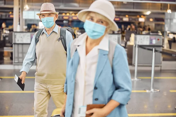 空港に立っている顔のマスクの乗客 — ストック写真