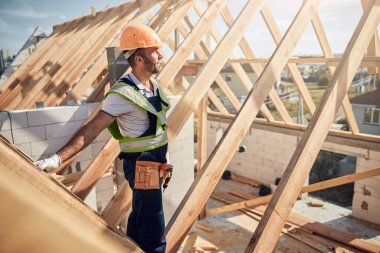 İnşaat alanında duran üniformalı bir adam.