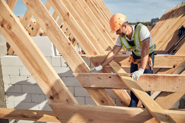 Construtor profissional na construção de equipamentos de proteção de um telhado — Fotografia de Stock