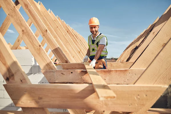 Konsantre inşaat işçisi çatı yapmak için odun kullanıyor. — Stok fotoğraf