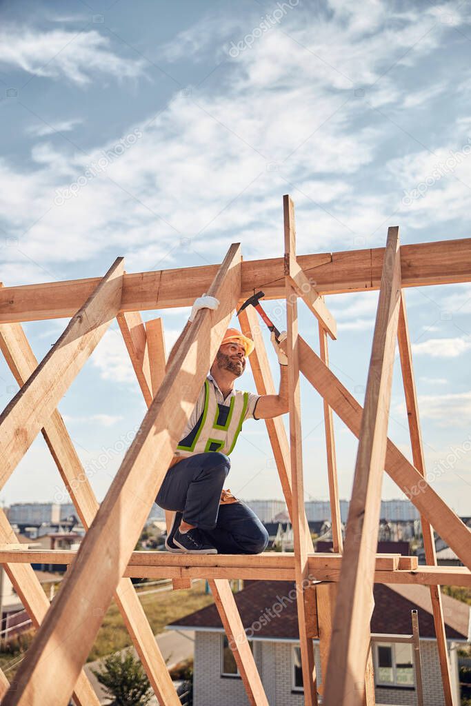 Builder in charge of a hammer-work at a construction site