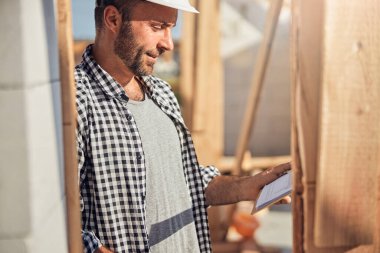 Nitelikli saha mühendisi inşaat alanındaki planını kontrol ediyor.