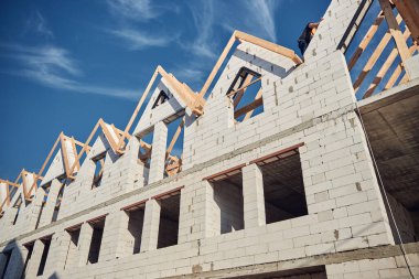 Profesyonel işçi beyaz bir binanın tepesine tırmanıyor.