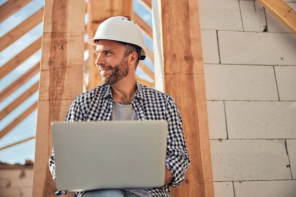 Jovem arquiteto alegre usando seu laptop ao ar livre — Fotografia de Stock