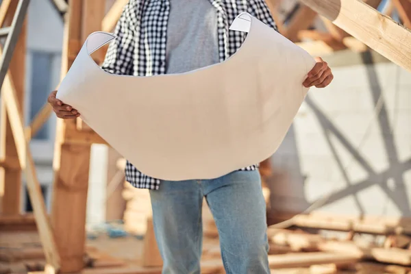 Ingeniero profesional sosteniendo un papel con un plan de construcción — Foto de Stock